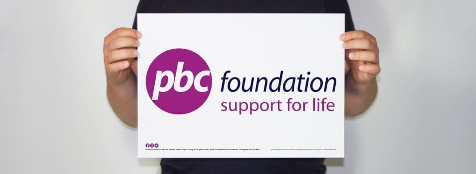 A supporter holding a PBC Foundation banner downloaded from this website